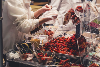 Midsection of man selling food at market stall