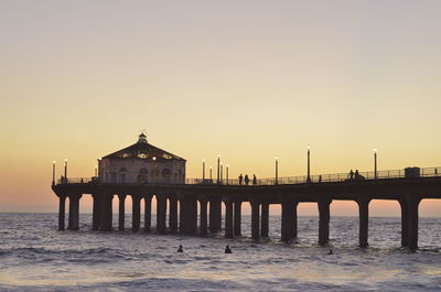 Pier in sea at sunset