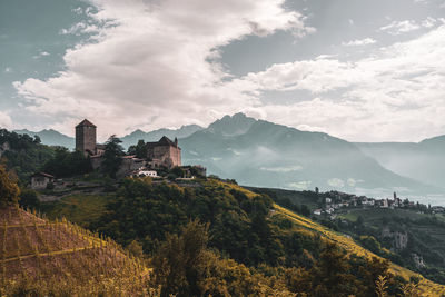 Scenic view of mountains and buildings against sky