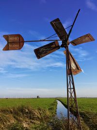 Traditional windmill on field against sky