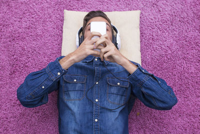 Young teenager with mobile phone and headphones at home