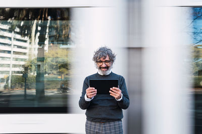 Portrait of young woman standing in city