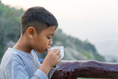 Portrait of boy drinking coffee