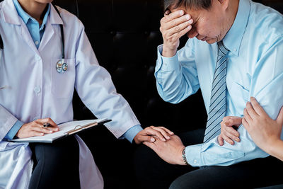 Man by doctor suffering from headache