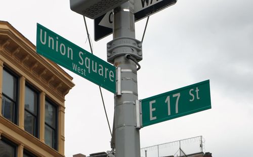 Low angle view of road sign against sky