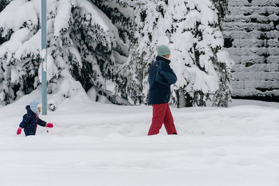 Rear view of woman skiing on snow covered mountain