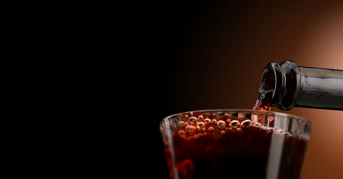 Close-up of drink pouring over black background