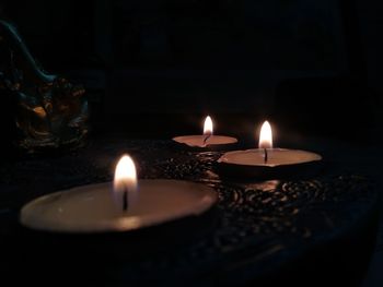 Close-up of lit tea light candles in temple