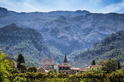 Scenic view of mountains and buildings against sky