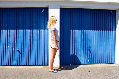 Woman standing against blue wall