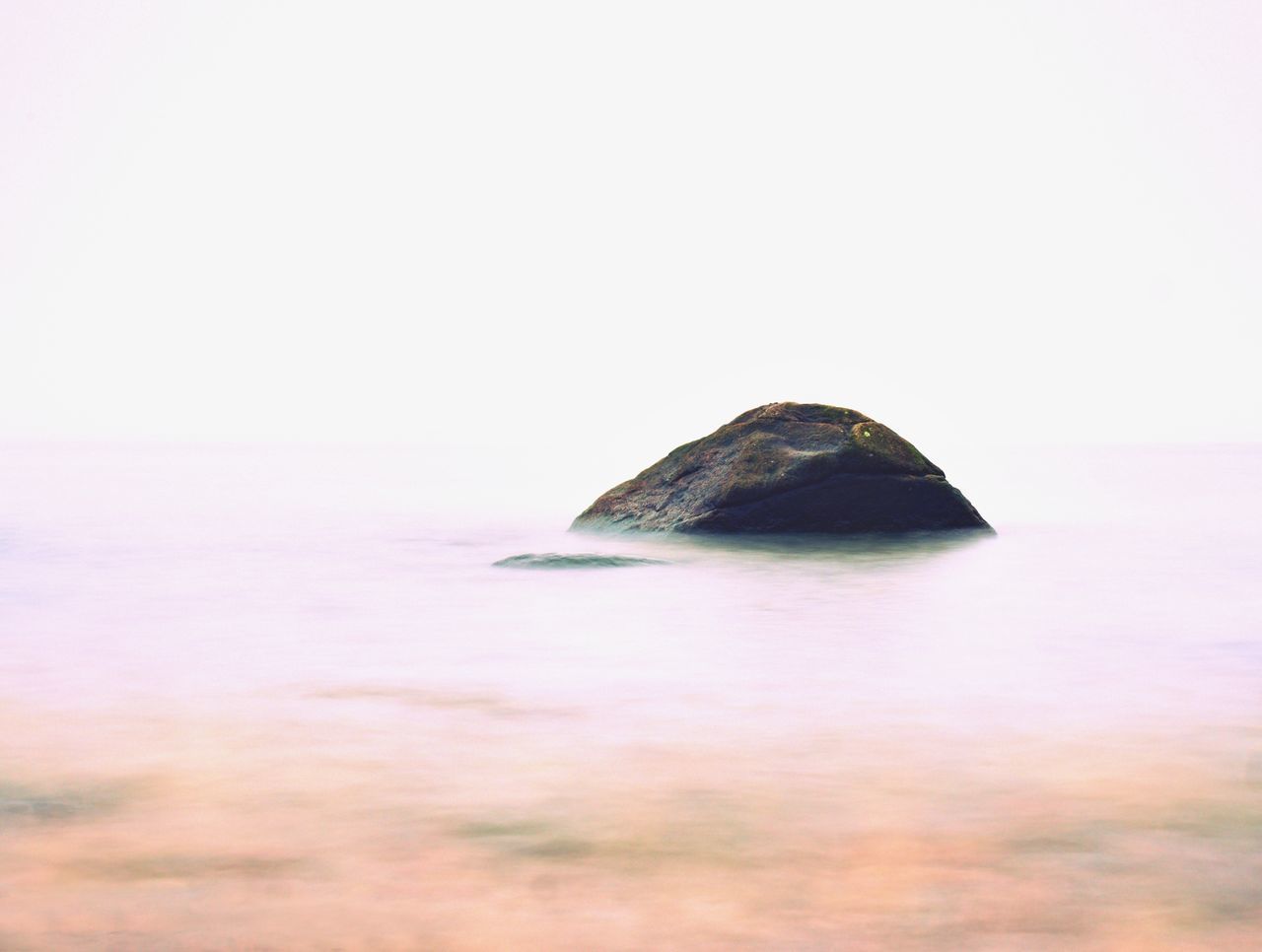 ROCK FORMATION IN SEA AGAINST SKY