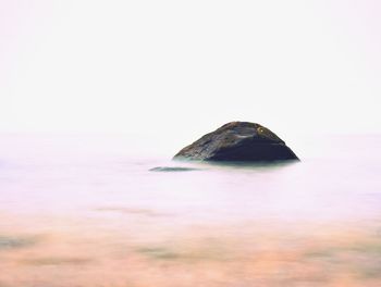 Scenic view of rocks in sea against sky