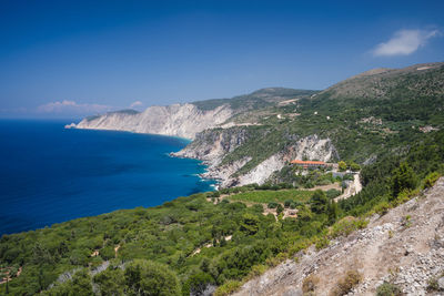 Scenic view of sea and mountains against blue sky