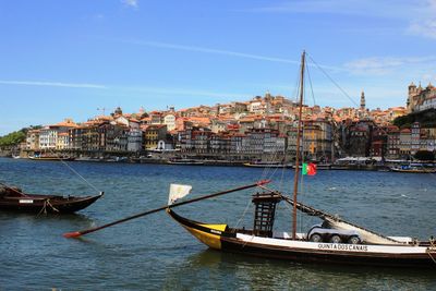Ship moored in city against sky