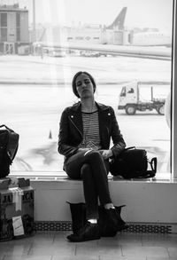 Woman sitting on bench in city