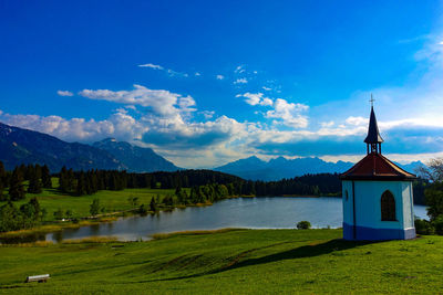 Scenic view of lake by mountains against blue sky