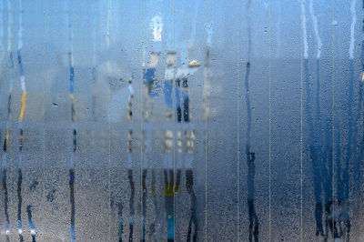 Full frame shot of glass window against blue wall