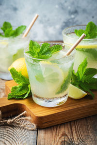 Two glass with lemonade or mojito cocktail with lemon and mint, cold refreshing drink.