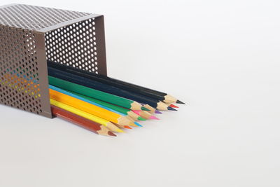 High angle view of multi colored pencils on white background