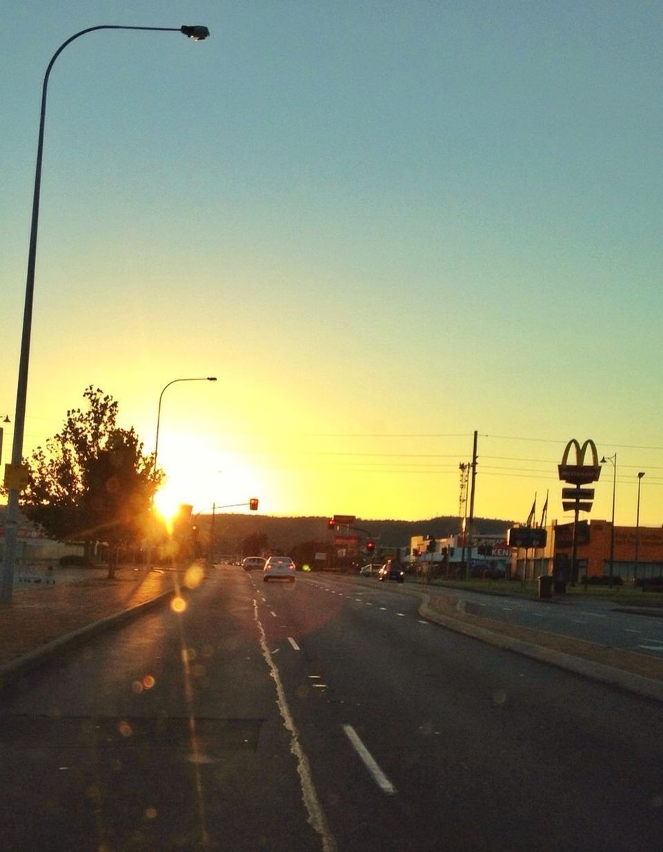 transportation, road, sunset, the way forward, road marking, car, sun, clear sky, street, street light, land vehicle, sunlight, diminishing perspective, mode of transport, sky, vanishing point, copy space, empty, outdoors, empty road