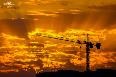 Silhouette crane against sky during sunset