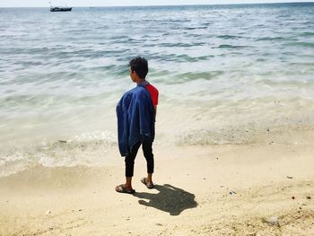 Rear view of man standing on beach