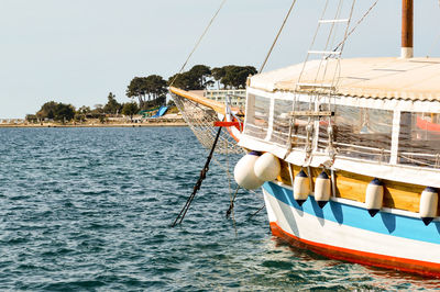 Boat sailing in sea against clear sky