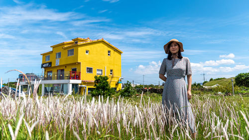 Woman standing on field against sky