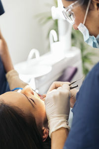 Female dentists examining woman teeth at hospital