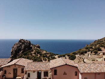 High angle view of buildings by sea against clear sky