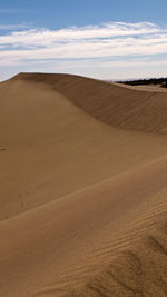 Sand dunes in desert against sky