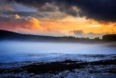 Scenic view of snow covered landscape during sunset