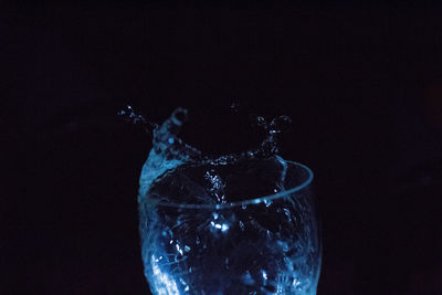 Close-up of glass splashing against black background