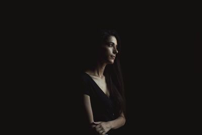 Portrait of a serious young woman over black background