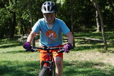 Boy riding bicycle on field