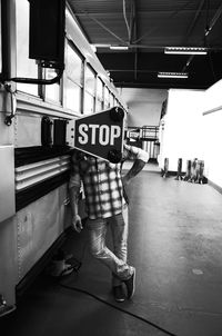 Rear view of man standing on railroad station