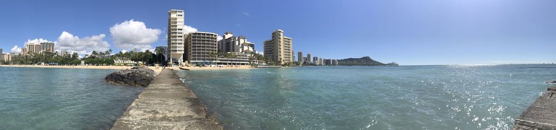 Panoramic view of sea and buildings against sky