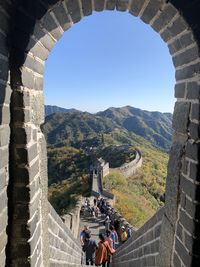 People walking on mountain against clear sky
