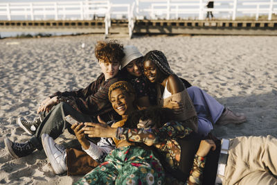 Happy multiracial lgbtqia friends enjoying at beach