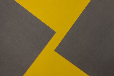 High angle view of yellow arrow sign on wall