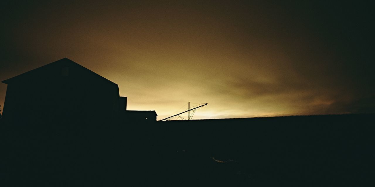 LOW ANGLE VIEW OF SILHOUETTE BUILDINGS AGAINST SKY AT SUNSET