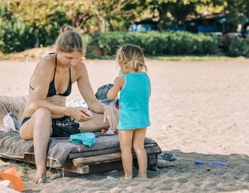 Rear view of women sitting on beach