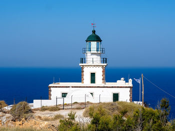 Lighthouse by sea against sky