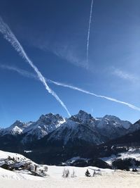 Scenic view of snowcapped mountains against blue sky