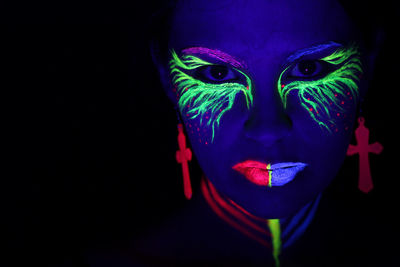 Portrait of man wearing mask against black background