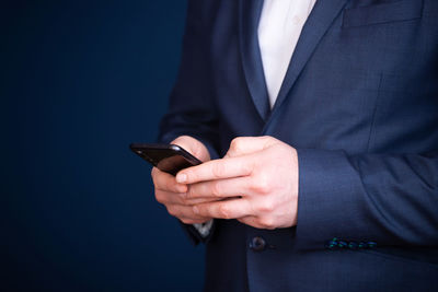 Midsection of businessman using mobile phone