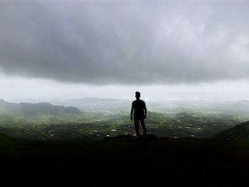 Man standing on mountain against sky