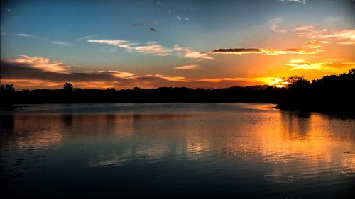 Scenic view of lake against romantic sky at sunset