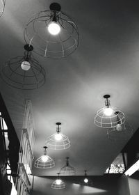 Low angle view of illuminated pendant lights hanging from ceiling