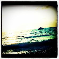 Boat sailing in sea at sunset